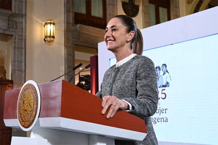 President Sheinbaum stands a podium during her morning press conference, where she discussed flights eliminated by Mexicana airline and other topics.