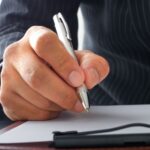 A businessman signing a letter