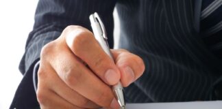 A businessman signing a letter