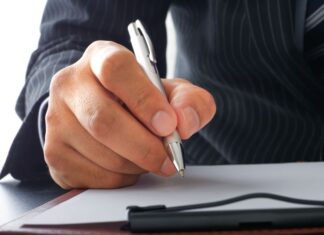 A businessman signing a letter