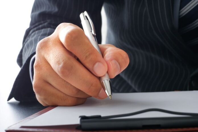 A businessman signing a letter