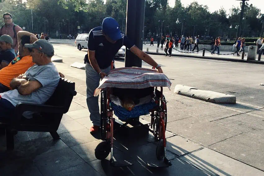 A man trying to figure out what is wrong with his wheelchair