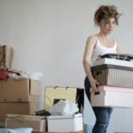 A woman organizing her stuff in a messy room