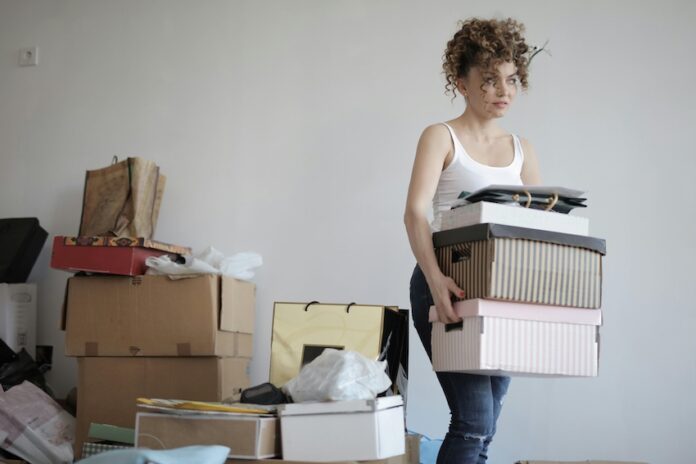 A woman organizing her stuff in a messy room