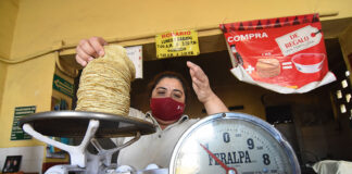 A woman weighs tortillas for sale, representing inflation in Mexico