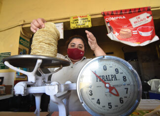 A woman weighs tortillas for sale, representing inflation in Mexico