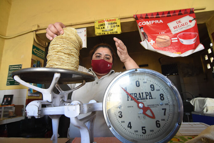 A woman weighs tortillas for sale, representing inflation in Mexico