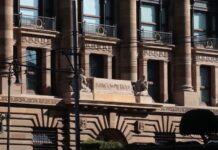 Facade of Bank of Mexico building in Mexico City, done in a classical style of architecture with arches, pillars, and balconies at each upper floor window