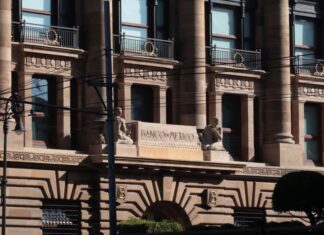 Facade of Bank of Mexico building in Mexico City, done in a classical style of architecture with arches, pillars, and balconies at each upper floor window