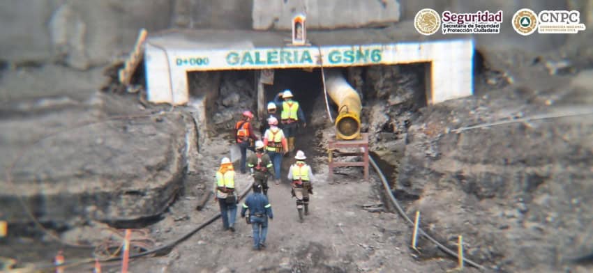 Men in construction and emergency gear walking into a temporary entrance to the collapsed El Pinabete mine in Coahuila. Painted on the entrance is "Galeria GSN6," a location marker for emergency personnel.