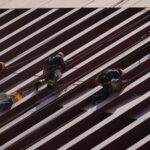 Men in construction gear in Mexico City scaling a row of steel girders on a building.