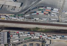 An aerial view of semitrailers waiting in long lines for customs at a US-Mexico border crossing, which are facing delays this week