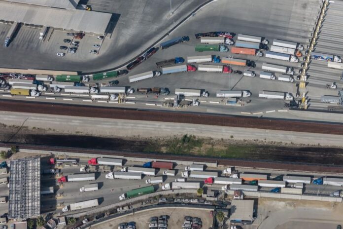 An aerial view of semitrailers waiting in long lines for customs at a US-Mexico border crossing, which are facing delays this week