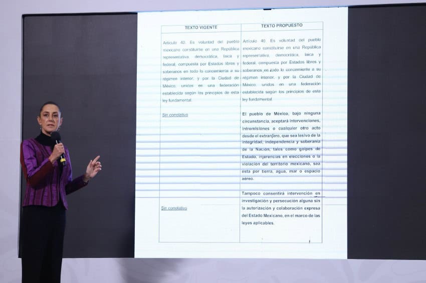 President Claudia Sheinbaum standing next to a projection screen with blown up copy of text of Article 40 of the Mexican constitution on one half of the screen and proposed revision of said article on the other.