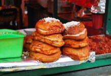 Pambazo sandwiches sit stacked on the edge of a food stall