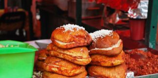 Pambazo sandwiches sit stacked on the edge of a food stall
