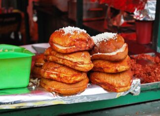 Pambazo sandwiches sit stacked on the edge of a food stall