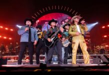 The band Grupo Firme plays together on a stage