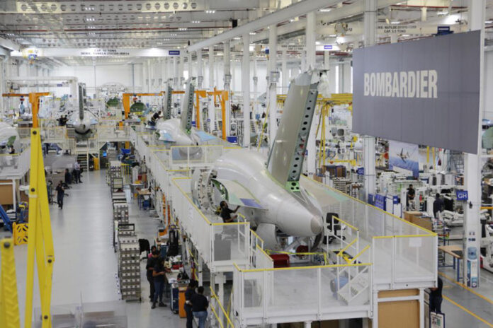 Bombardier aircraft parts manufacturing floor in Queretaro, Mexico, with a large sign that says 