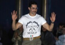 Mexican designer Patrick Campillo on a New York Fashion Week runway wearing a white T-shirt reading "El Golfo de México" with dolphins and a Mexican flag