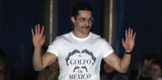 Mexican designer Patrick Campillo on a New York Fashion Week runway wearing a white T-shirt reading "El Golfo de México" with dolphins and a Mexican flag
