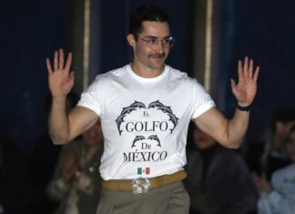 Mexican designer Patrick Campillo on a New York Fashion Week runway wearing a white T-shirt reading "El Golfo de México" with dolphins and a Mexican flag