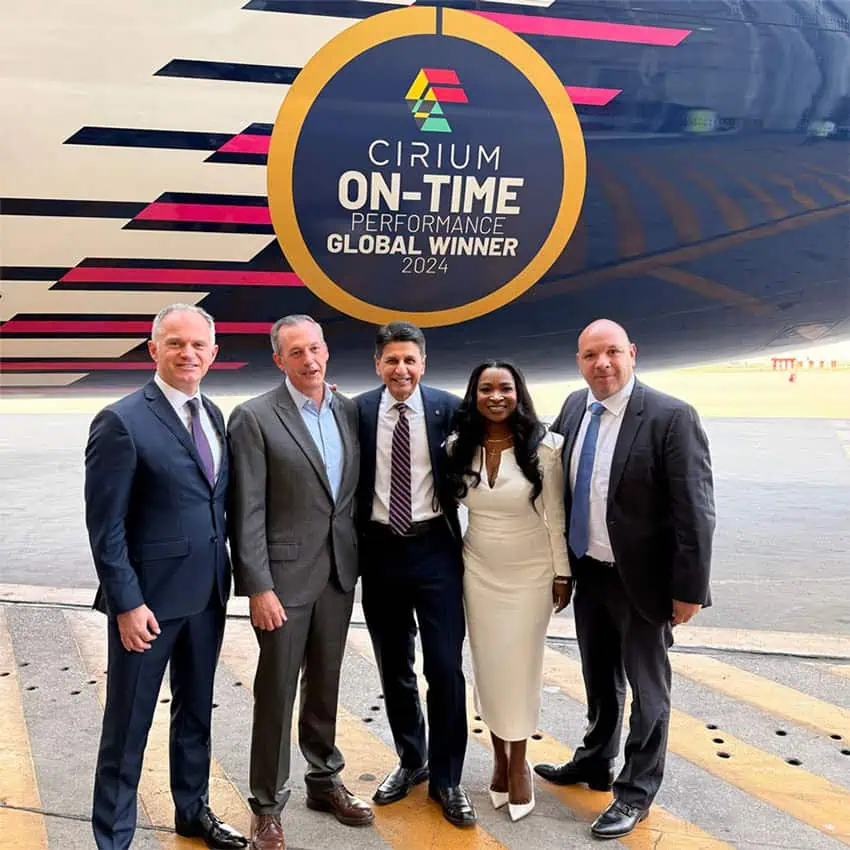 Aeroméxico CEO Andrés Conesa and other officials in front of a plane with a sticker reading Cirium On-Time Global Winners