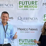 Travis and Tamanna Bembenek stand smiling in front of a banner reading Mexico News Daily, Querencia and Future of Mexico