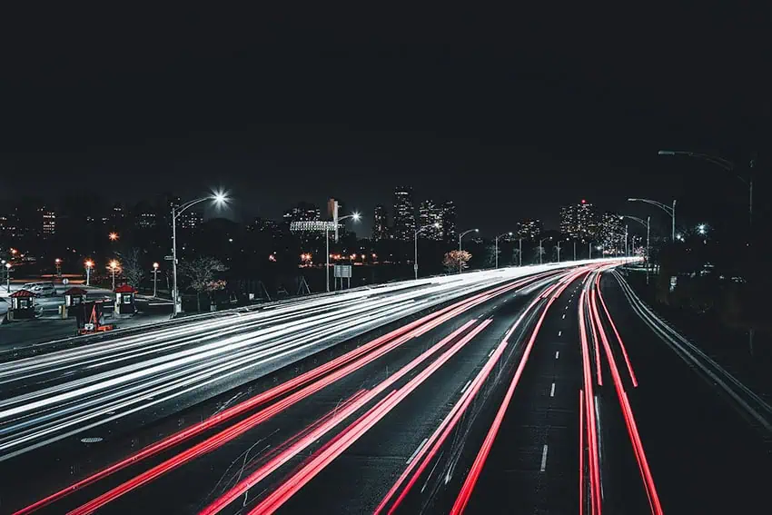 A highway at night with streaks of headlights captured by a long-exposure photo