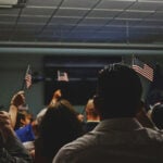 Immigrants wave American flags at a U.S. citizenship ceremony