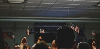 Immigrants wave American flags at a U.S. citizenship ceremony
