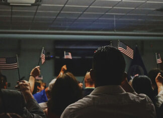 Immigrants wave American flags at a U.S. citizenship ceremony