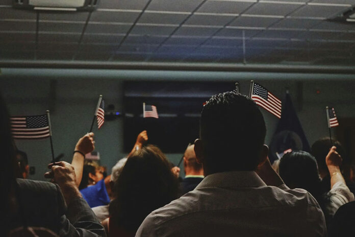 Immigrants wave American flags at a U.S. citizenship ceremony