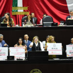 Members of the Mexican Chamber of Deputies hold signs related to the ban on GM corn reading "Somos los hijos del maiz"