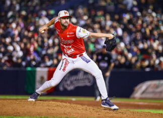 A baseball pitcher in a red Mexican uniform throws the ball at a Caribbean Series Mexico vs Dominican Republic game