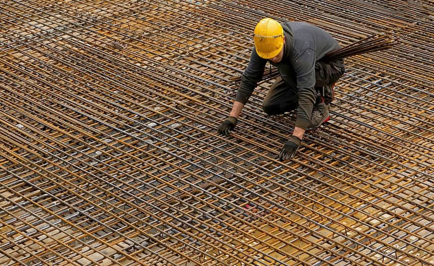 A construction worker lays down steel rebar, like that which could be subject to tariffs in Mexico