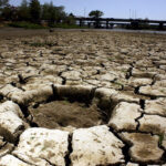 Cracks run through the dirt in a dried-out reservoir, representing intense drought in northwest Mexico