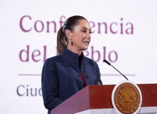 President Sheinbaum at the podium of her Monday mañanera conference, where she discussed Ebrard's plans to attend tariff talks in the U.S.