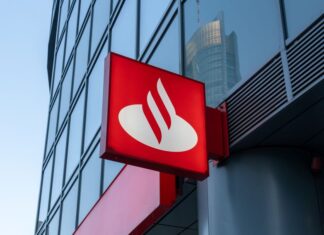 Sign with logo for Santander Bank, which has a red background and a stylized abstract image of a white swan. The sign is bolted toward the base of a skyscraper building.