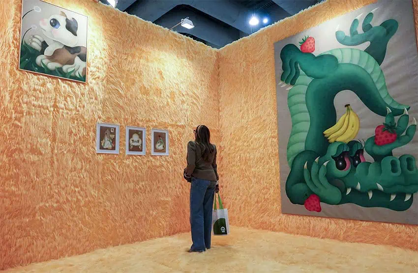 A woman looks at paintings during Zona Maco at Mexico City Art Week 2025