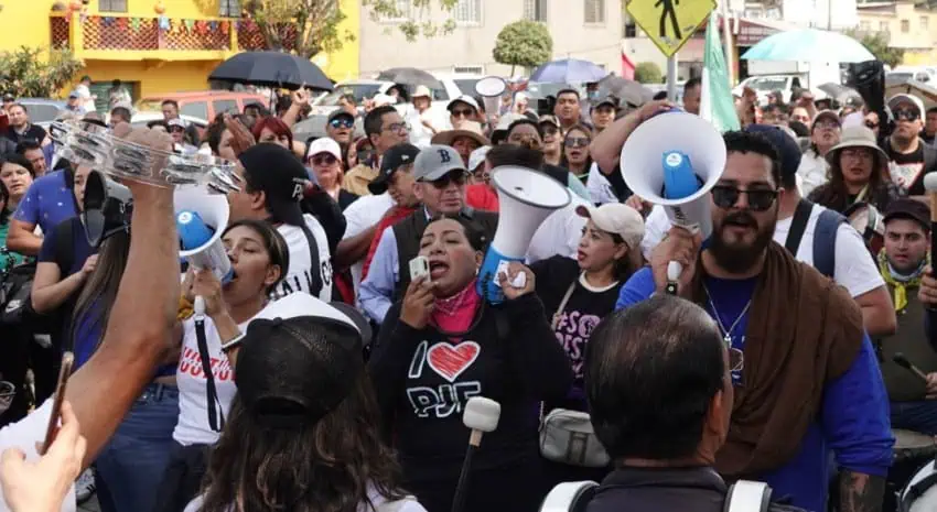 Una multitud de manifestantes que sostienen megáfonos en una calle de la ciudad