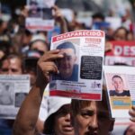 People holding signs seeking missing persons in Jalisco