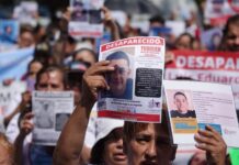 People holding signs seeking missing persons in Jalisco