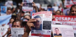 People holding signs seeking missing persons in Jalisco