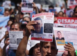 People holding signs seeking missing persons in Jalisco