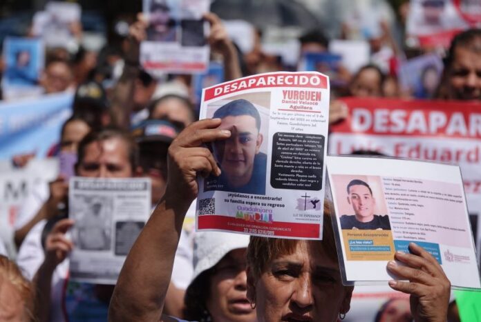 People holding signs seeking missing persons in Jalisco