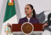 President Claudia Sheinbaum standing at the presidential podium during her daily press conference, speaking about tariffs on Mexican exports.