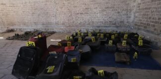Shoes, clothes and backpacks marked with yellow forensic tags at a ranch in Teuchitlán, Jalisco