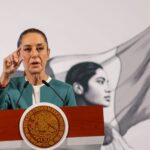 Claudia Sheinbaum at her daily press conference. She is gesturing with her thumb and forefinger to reporters as she speaks in the press briefing room at the National Palace