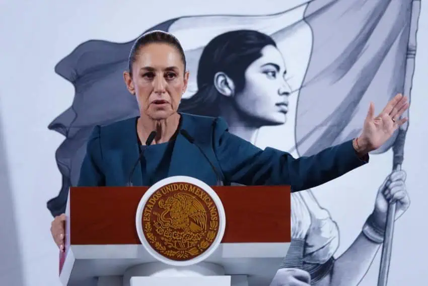 Mexico's President Claudia Sheinbaum at the presidential podium at her daily press conference. She is talking to reporters off camera about the reasons Mexico has hired Cuban doctors to work in Mexican public hospitals.